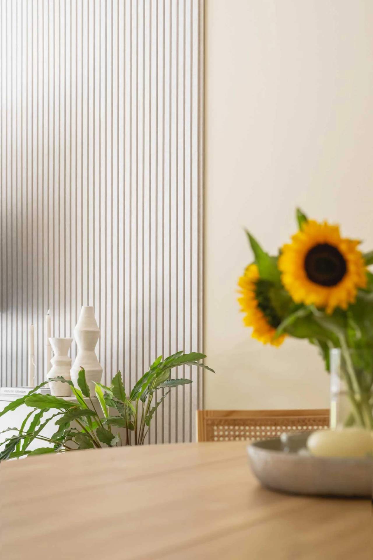 Eetkamerhoek met paneelwand en zonnebloemen